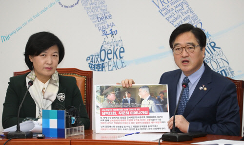 우원식 민주당 원내대표가 23일 국회에서 열린 최고위원회의에서 지난 2014년 10월 판문점 남쪽지점서 열린 남북정상급 군사회담 당시 북측 수석 대표였던 김영철과 남측 유재승 국방정책실장의 사진, 새누리당 논평 사진을 근거로 한국당을 비판하고 있다./연합뉴스